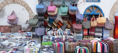 Imagen de muestra de un puesto en un mercado marroquí con una variedad de telas y bolsos coloridos en exposición en la que se muestra la resolución